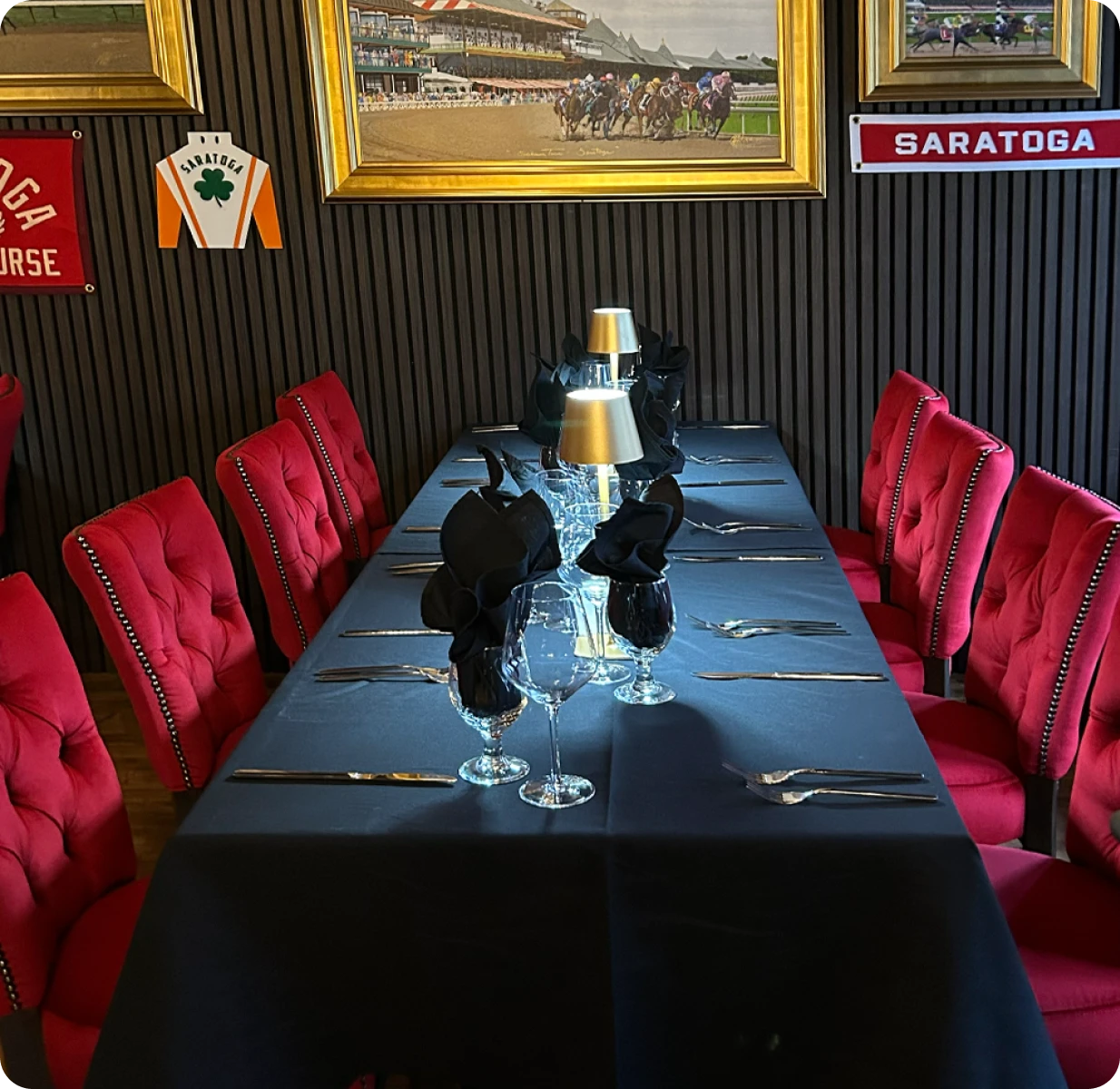 Private dining table set with red velvet chairs, Saratoga horse racing memorabilia on the walls